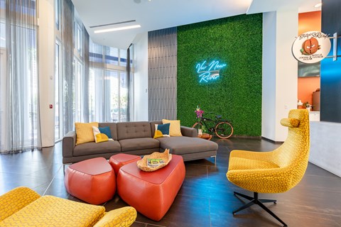 a living wall with a neon sign in a living room with couches
